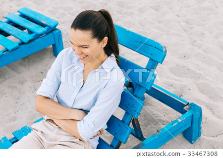 Cute young woman sitting on a bench 33467308