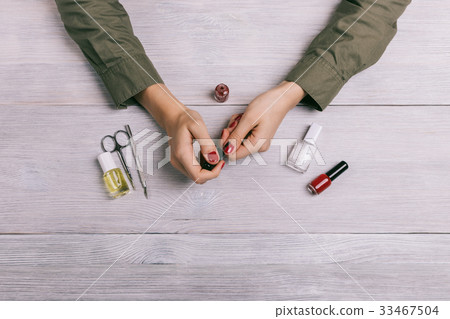 Female hands make manicure and paint nails Female hands make manicure and paint nails 33467504