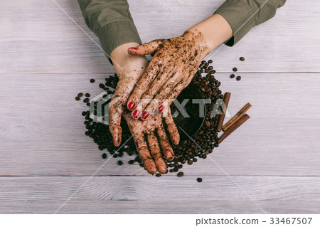 Female hands rubbing the coffee scrub closeup Female hands rubbing the coffee scrub closeup 33467507