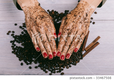 Female hands with red manicure and coated scrub Female hands with red manicure and coated scrub 33467508
