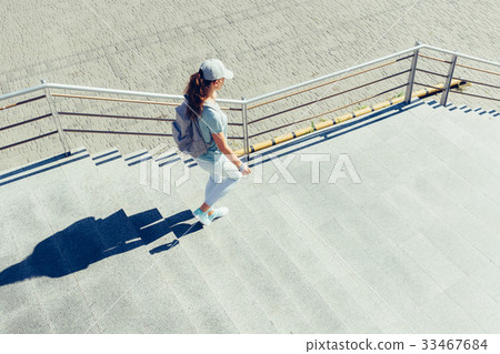 Slender woman in a cap and with backpack Slender woman in a cap and with backpack 33467684