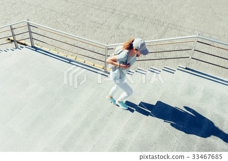 Slim woman in a cap and with a backpack Slim woman in a cap and with a backpack 33467685