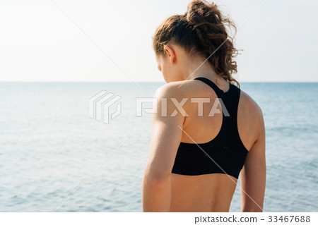 Athletic girl with curly hair in a sports bra Athletic girl with curly hair in a sports bra 33467688