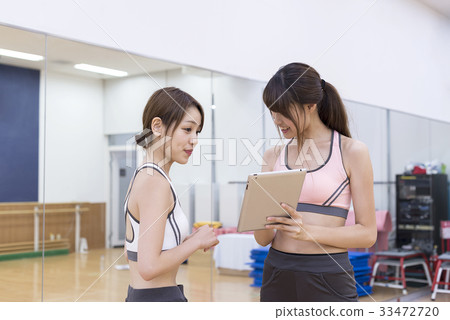 Young woman checking training content on fitness gym tablet Young woman checking training content on fitness gym tablet 33472720