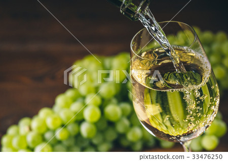 Beautiful White wine in glass with a bunch grapes Beautiful White wine in glass with a bunch grapes 33476250