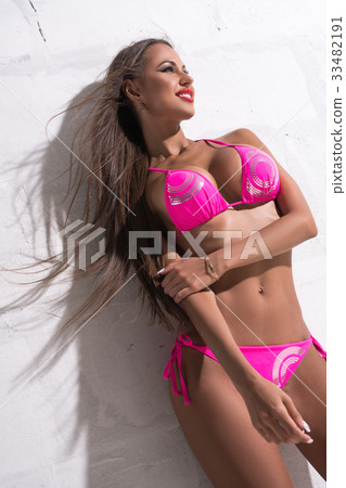 Gorgeous brunette against white wall sunny shot 33482191