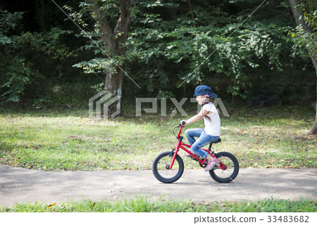 A girl playing with a red bicycle A girl playing with a red bicycle 33483682