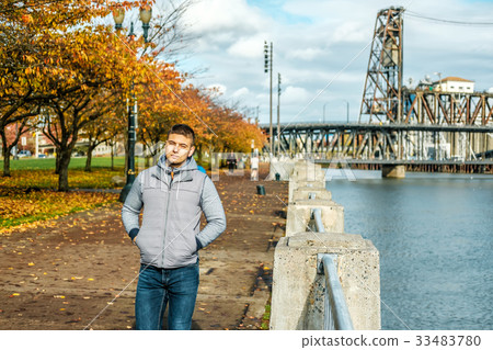 Man walking along the riverwalk in Portland city at autumn 33483780