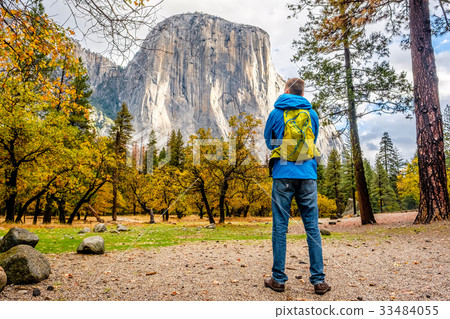 Tourist with backpack hiking in Yosemite National Park Valley at cloudy autumn morning 33484055
