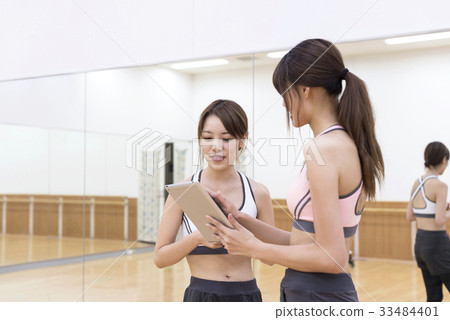 Young woman checking training content on fitness gym tablet 33484401