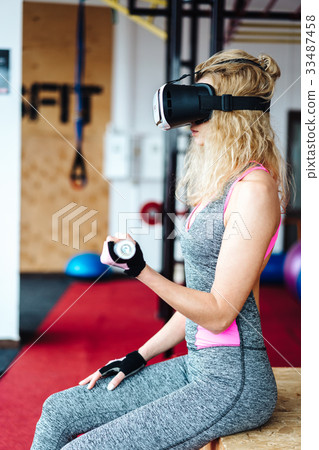 Beautiful girl in the gym with VR headset Beautiful girl in the gym with VR headset 33487458