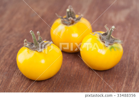 Three yellow eggplant on wooden 33488356