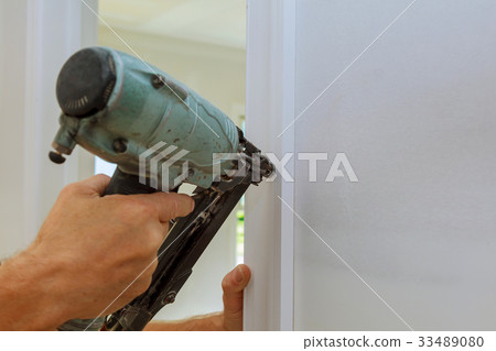 Carpenter brad using nail gun to moldings doors, Carpenter brad using nail gun to moldings doors, 33489080