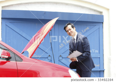 Businessman making an assessment of a car Businessman making an assessment of a car 33492284