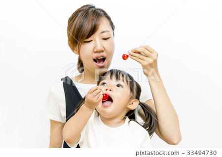 Little girl eating cherries in parent and child Little girl eating cherries in parent and child 33494730