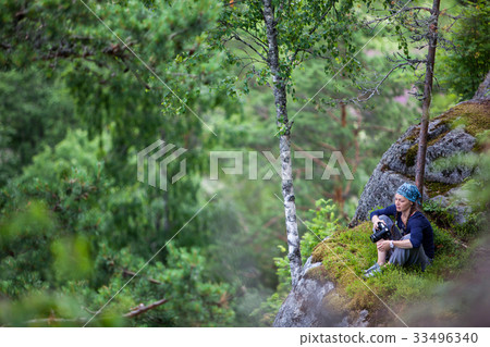 Beautiful girl tourist stands on a rock to 33496340