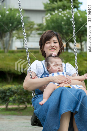 Baby and mother playing on the swing 33496403