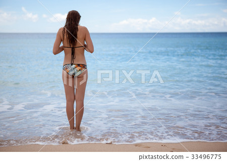 A young girl is going to swim in the ocean. sea 33496775