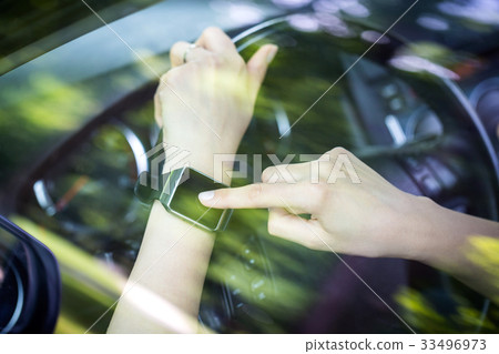 A woman uses smartwatch in the car. A woman uses smartwatch in the car. 33496973