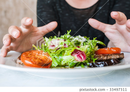 Woman attacks medallions with salad Woman attacks medallions with salad 33497311