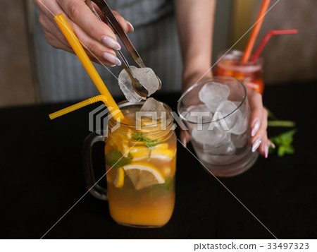 Waiter preparing orange fruit cocktails Waiter preparing orange fruit cocktails 33497323