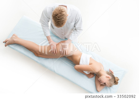 View of massagyst massaging slim woman in saloon View of massagyst massaging slim woman in saloon 33502092