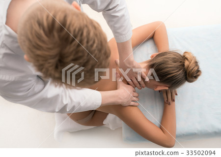 Blonde enjoying neck massage in saloon top view Blonde enjoying neck massage in saloon top view 33502094