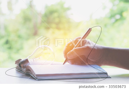 Close up hand writing on book paper with pencil Close up hand writing on book paper with pencil 33503673