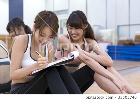 Young woman checking fitness gym training content Young woman checking fitness gym training content 33503746