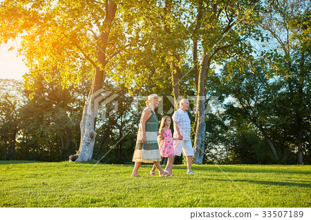 Seniors with granddaughter, summer day. 33507189