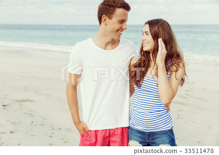 Romantic young couple standing on the beach 33511478