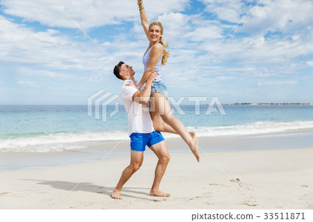Happy couple jumping on beach vacations Happy couple jumping on beach vacations 33511871