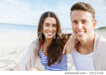 Romantic young couple sitting on the beach 33512156