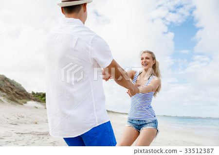 Happy couple having fun on the beach. Happy couple having fun on the beach. 33512387