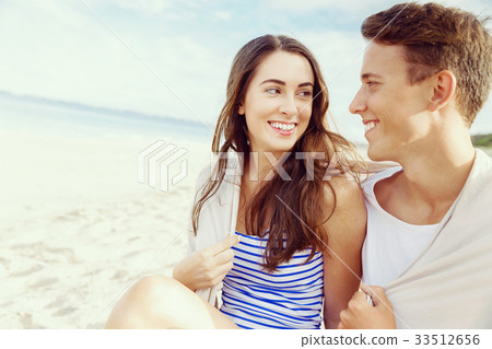 Romantic young couple sitting on the beach 33512656