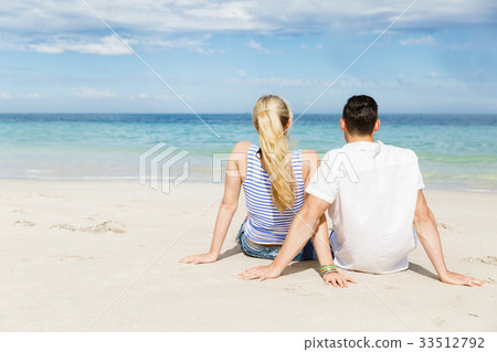 Romantic young couple sitting on the beach Romantic young couple sitting on the beach 33512792