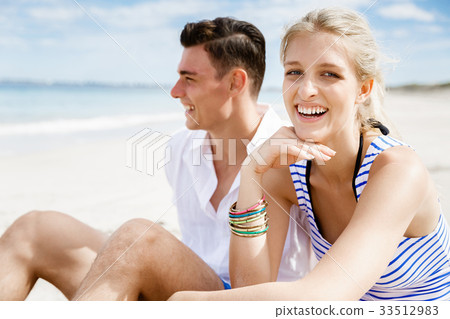 Romantic young couple sitting on the beach 33512983