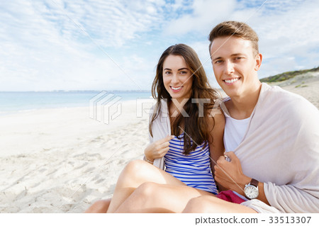 Romantic young couple sitting on the beach Romantic young couple sitting on the beach 33513307