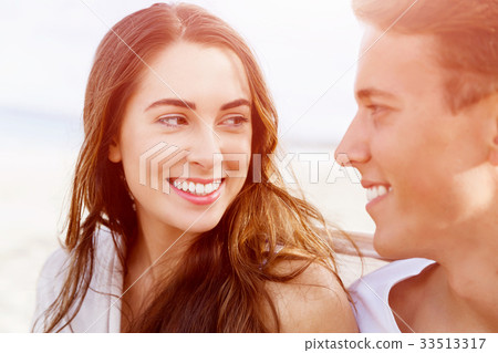 Romantic young couple sitting on the beach Romantic young couple sitting on the beach 33513317