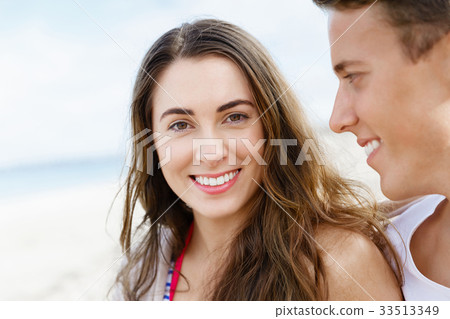 Romantic young couple sitting on the beach 33513349