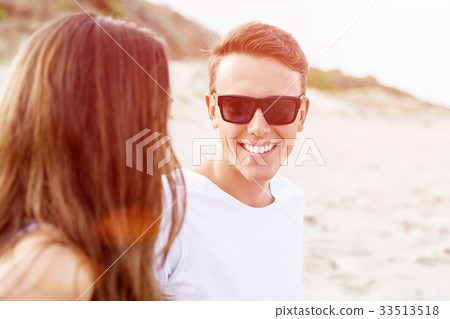 Romantic young couple sitting on the beach Romantic young couple sitting on the beach 33513518