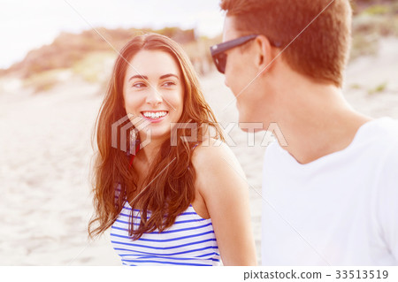 Romantic young couple sitting on the beach Romantic young couple sitting on the beach 33513519