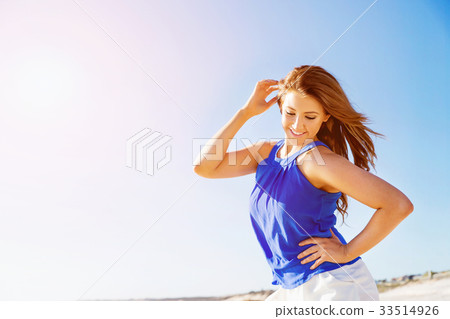 Young woman walking along the beach Young woman walking along the beach 33514926