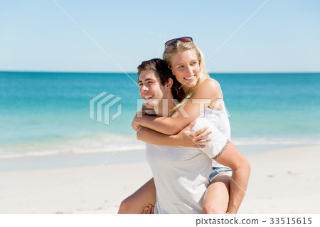 Portrait of man carrying girlfriend on his back 33515615