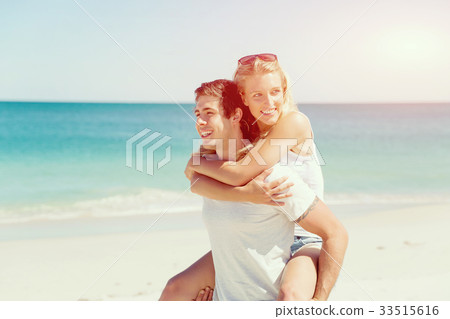 Portrait of man carrying girlfriend on his back 33515616