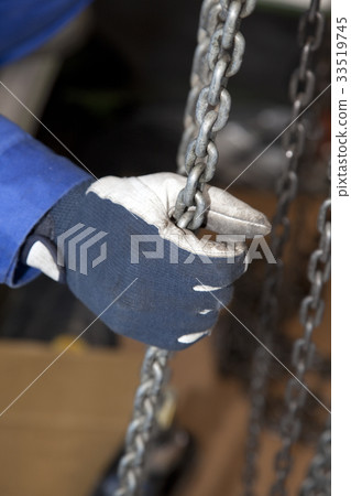 Worker hand pulling a chain block Worker hand pulling a chain block 33519745