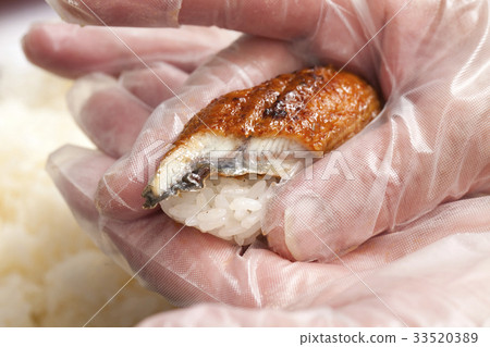 Sushi held with cooking gloves Sushi held with cooking gloves 33520389