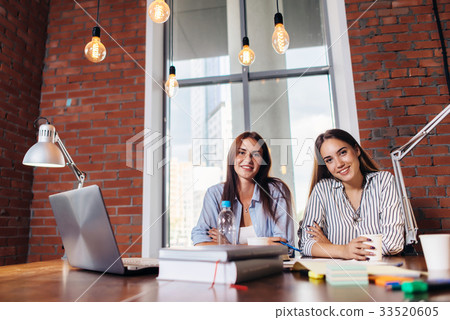 Portrait of two female students smiling, sitting Portrait of two female students smiling, sitting 33520605