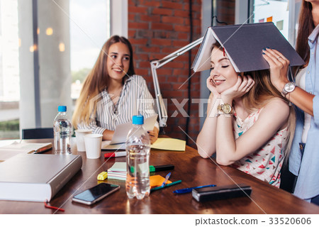 Group of cheerful college students doing homework Group of cheerful college students doing homework 33520606