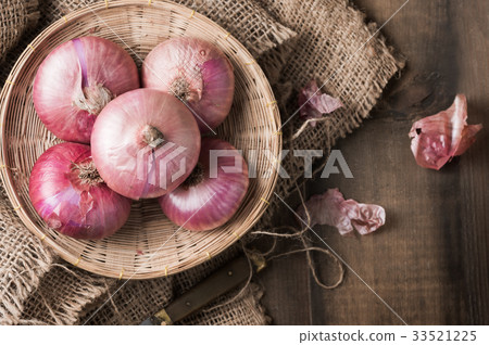 red onions in bamboo basket and on wood  33521225